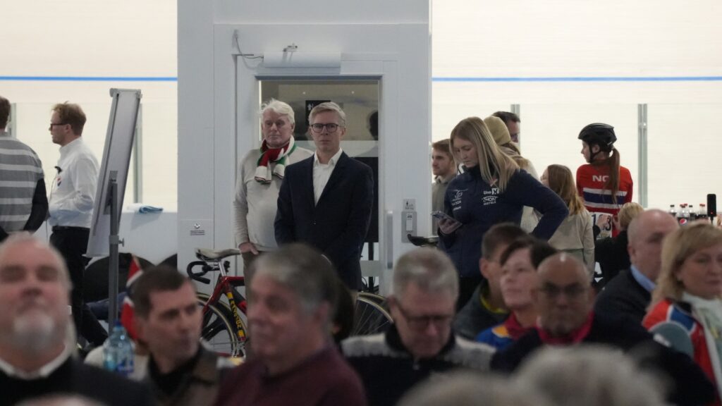 Arenaleder Truls Veslum (sort jakke) ser utover idrettsflaten og menneskene som møtte opp på åpningsdagen.